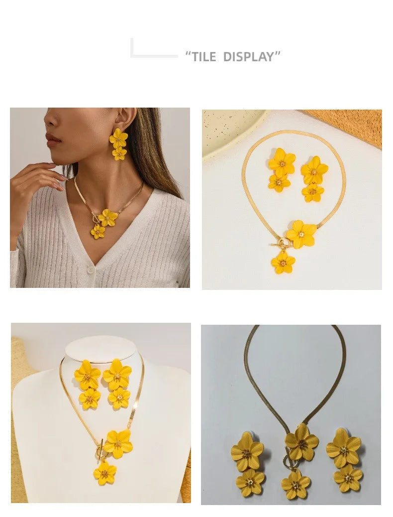 A gold-toned floral pendant necklace and matching earrings set featuring yellow flowers.