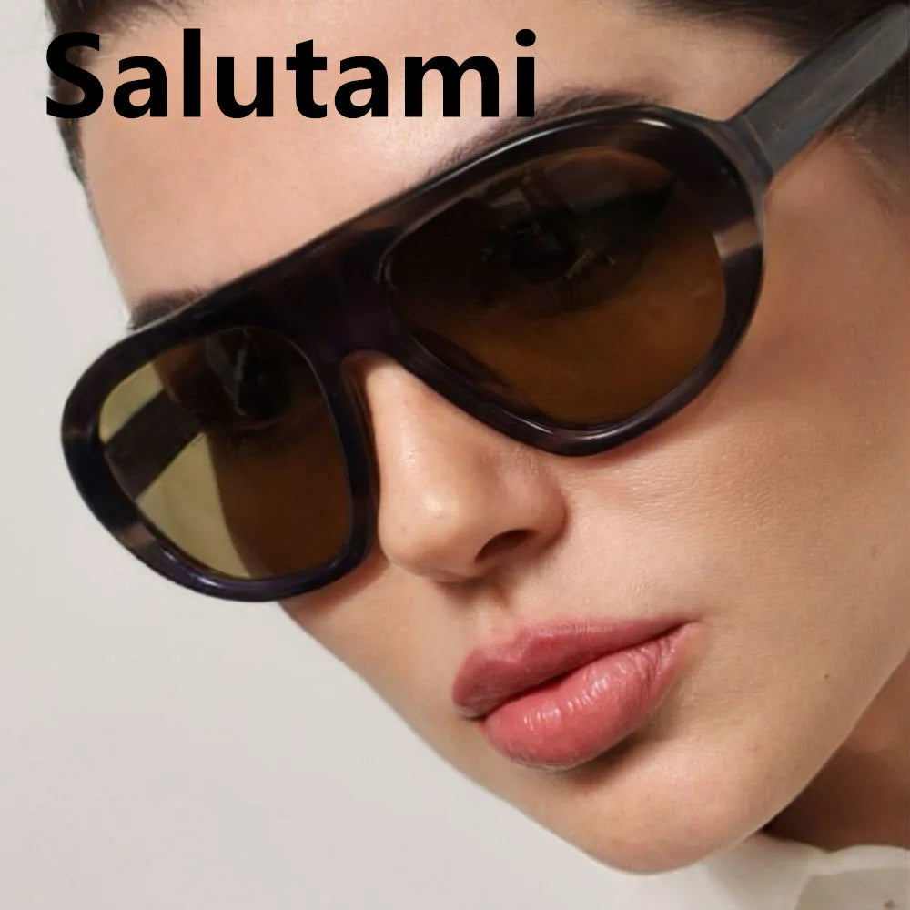 A close-up of a woman wearing dark brown gradient sunglasses.