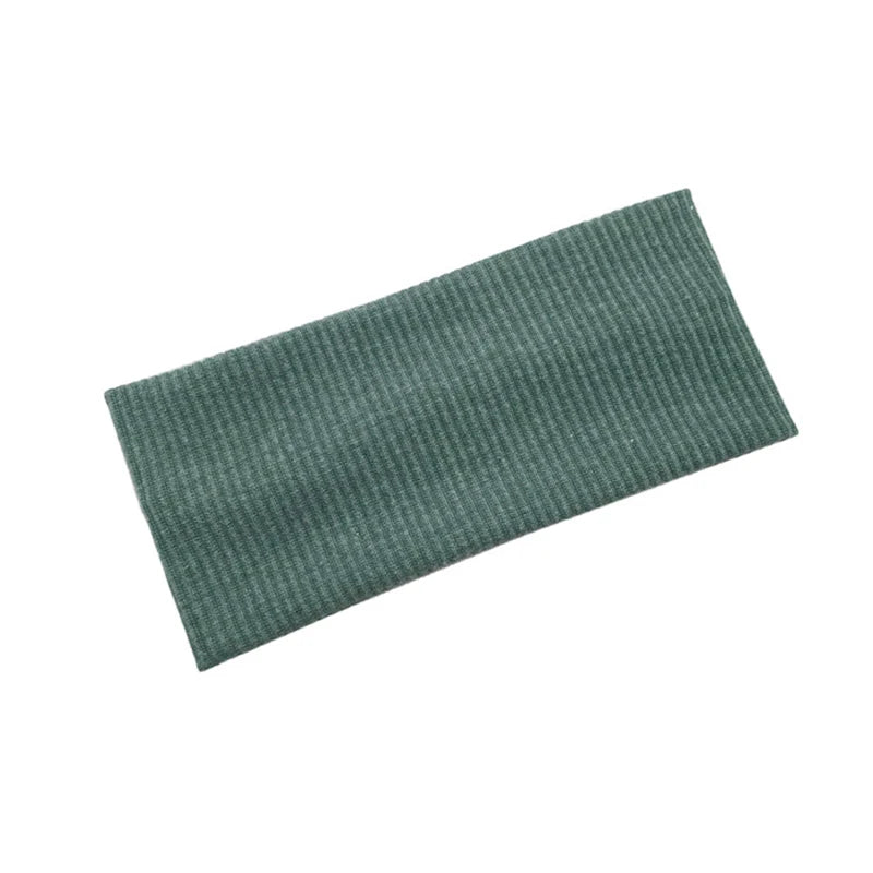 A dark green knitted sports headband for yoga and gym