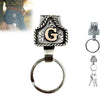 Silver and black letter G pendant on a ring with a leather strap keychain.