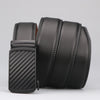A black men's genuine leather ratchet dress belt coiled and displayed on a light gray background.
