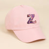 A pink baseball cap featuring a purple and iridescent unicorn letter Z embroidered on the front.
