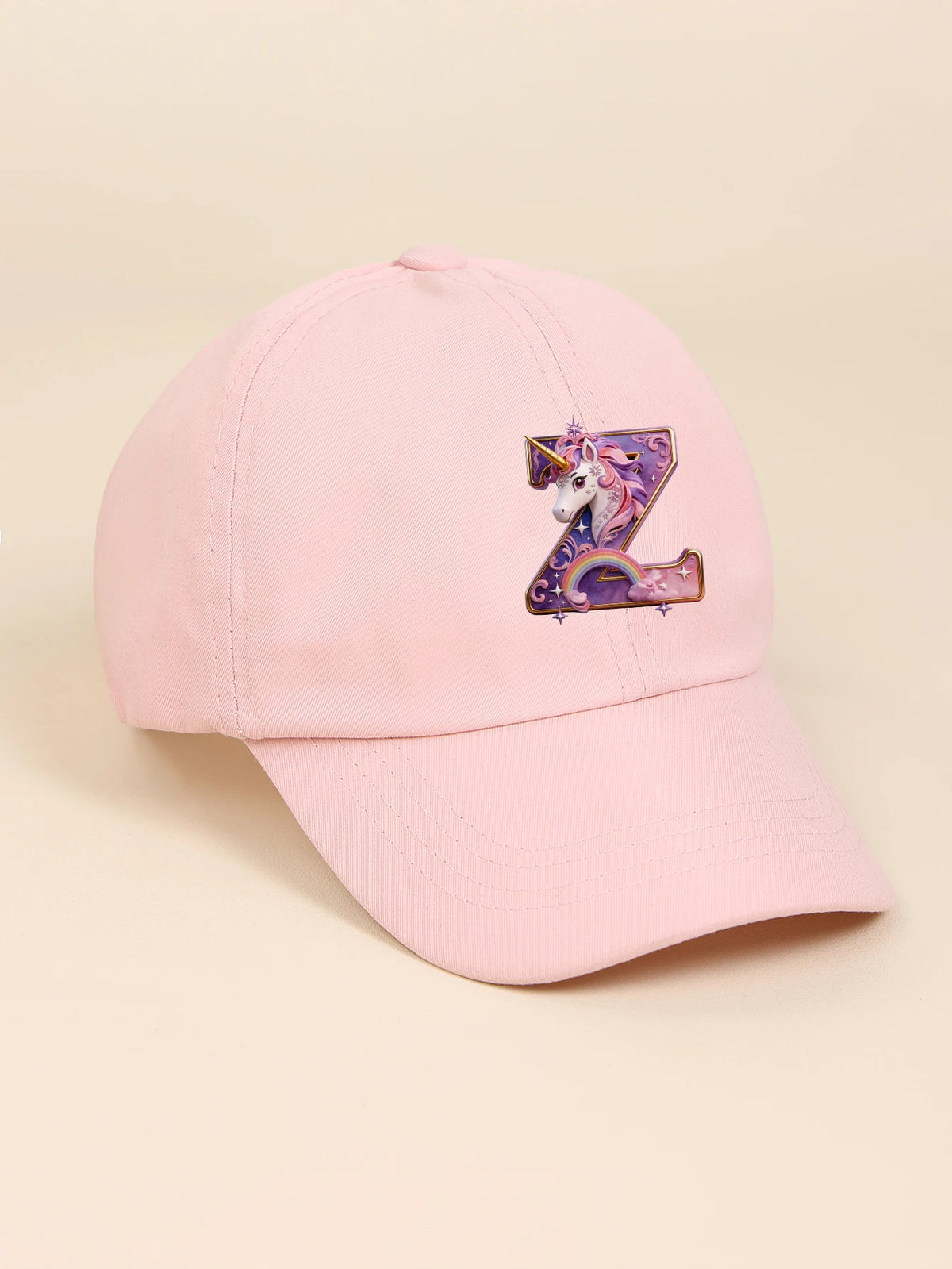 A pink baseball cap featuring a purple and iridescent unicorn letter Z embroidered on the front.