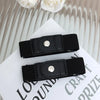 A black buckle-free elastic casual belt is shown lying on a white surface.