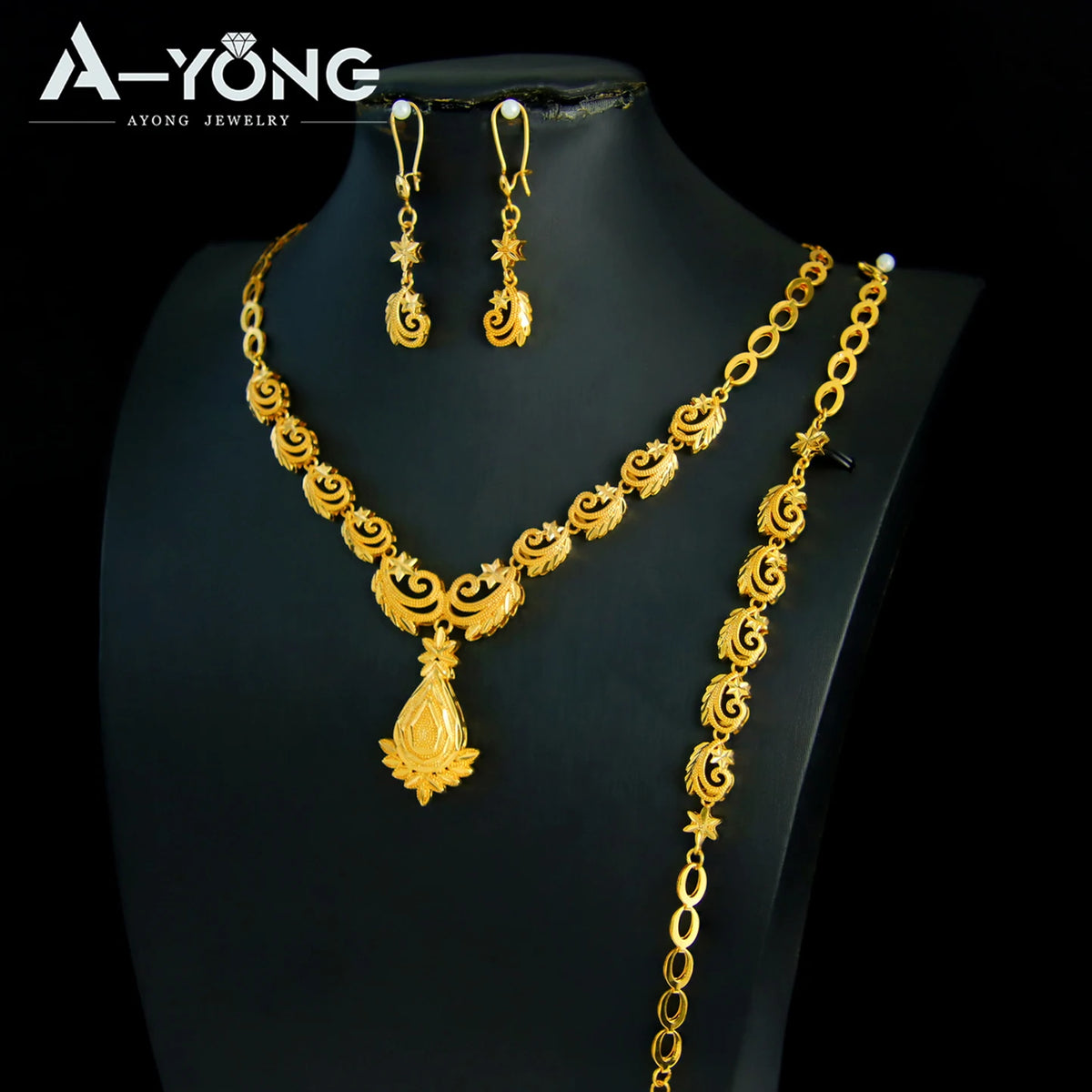 A luxury gold plated bridal jewelry set featuring earrings and a necklace displayed on a black mannequin.