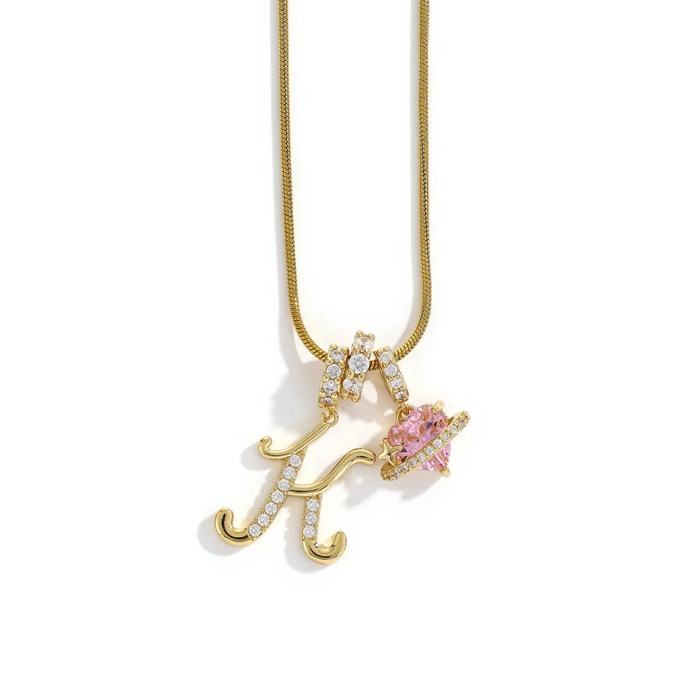 Gold letter K pendant necklace with a pink gemstone flower design