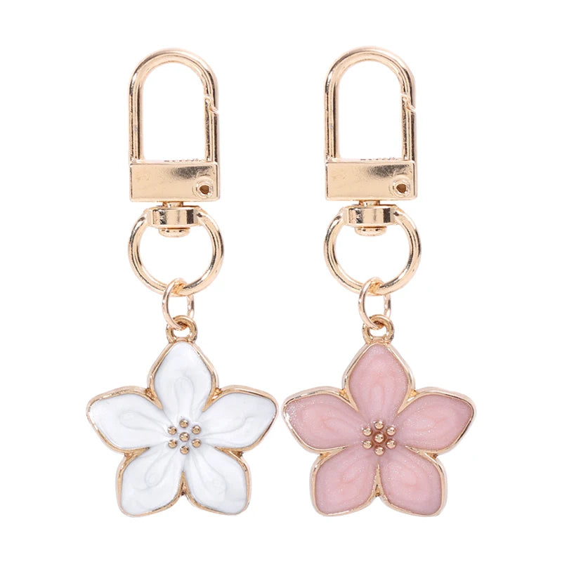 Llavero floral dorado con flor translúcida blanca y rosa