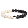 A black and white Yin Yang hand string bracelet featuring smooth, round beads.