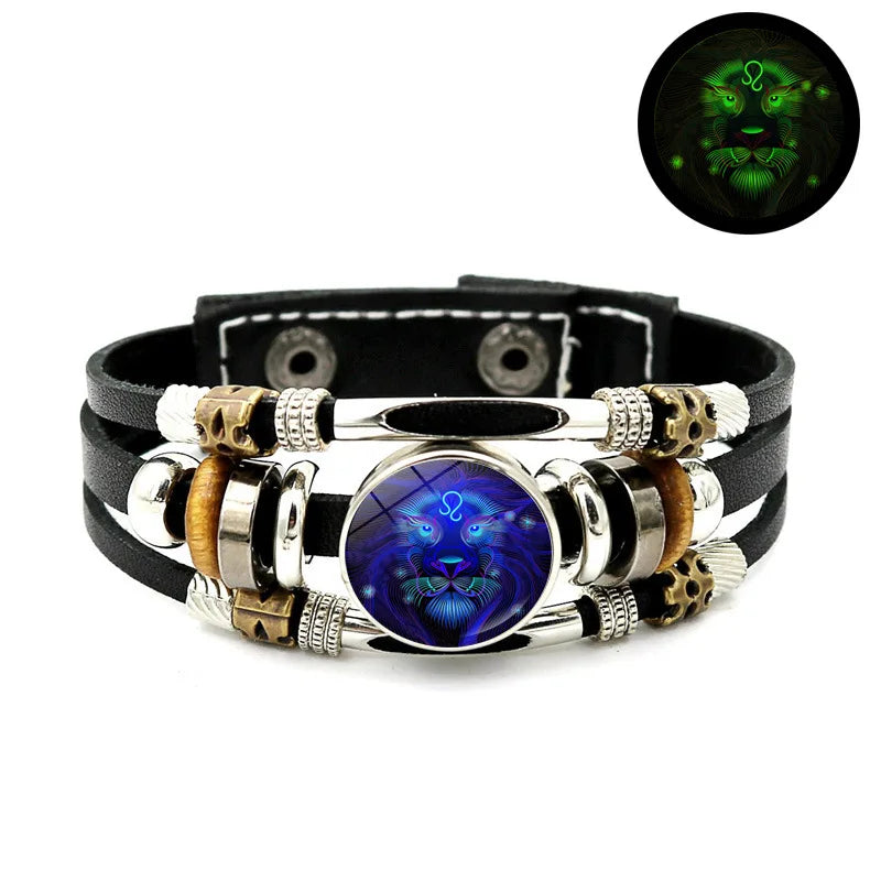 Schwarzes Lederarmband mit silbernen Perlen, goldenen Akzenten und einem blauen Edelstein mit Löwenkopf-Design.
