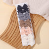 A display of pink, gray, and brown handmade ribbon bow hair clips arranged on a white card against a light background.