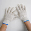 A pair of white cotton thread work gloves worn on a person's hands.