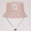 A beige sun hat for kids featuring a gold letter O design and a light beige strap.