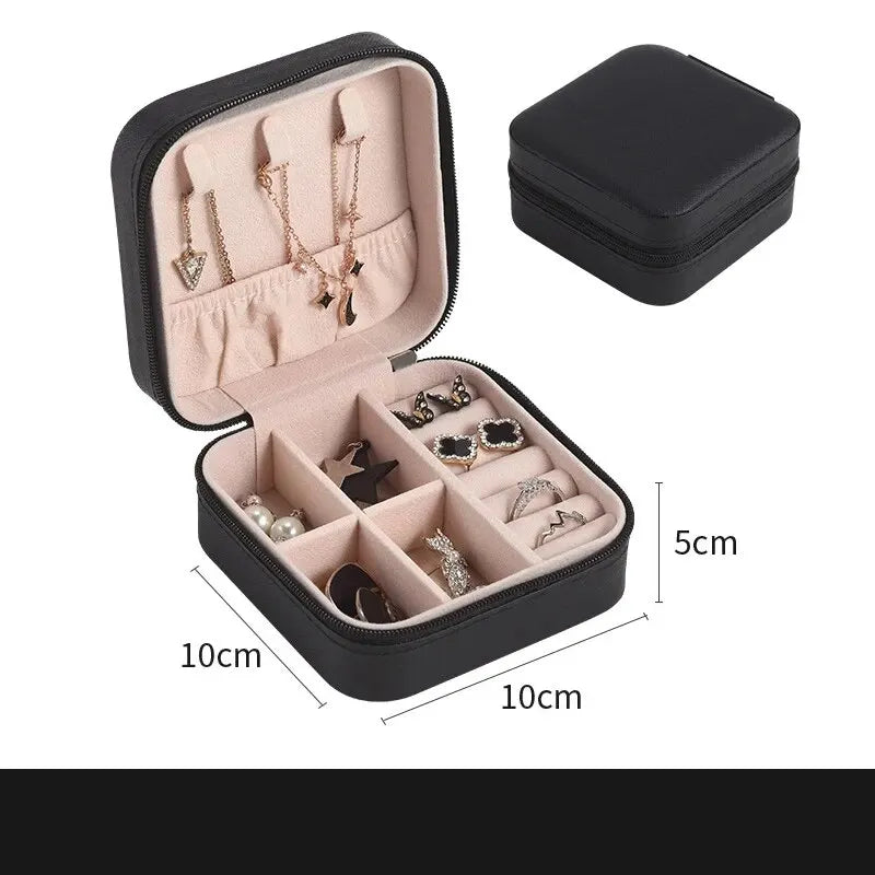 A black leather jewelry travel organizer box showing compartments for necklaces and rings.