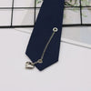 A silver chain necklace with a heart pendant is displayed against a dark blue necktie.