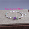 Sterling silver double heart charm bracelet featuring amethyst and green gemstone beads