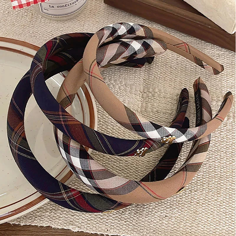 A collection of British plaid sponge headbands in various muted tones and patterns.