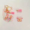 Alphabet letter L acrylic keychain with a pink butterfly tassel and gold hoop.
