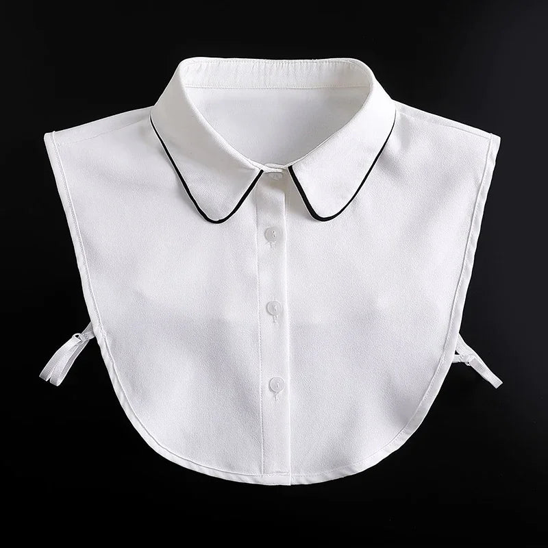 A white blouse with a fashionable false collar and detachable neckline, shown against a black background.