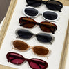 A collection of ten trendy leopard cat eye sunglasses in various shades of brown, black, and purple displayed on a white tray
