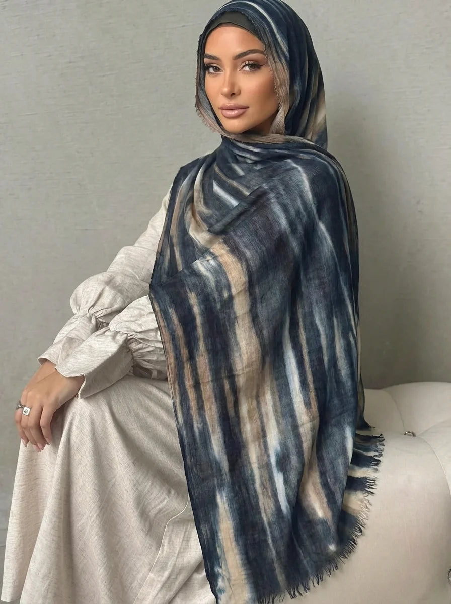 Una mujer vistiendo un elegante pañuelo de hijab de algodón rayado en azul y beige.
