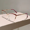 Un par de gafas de computadora con diseño de gato y marco de oro rosa con detalles rosas sobre una superficie blanca.
