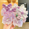 A collection of purple and white sheer lace flower bow hair ties for girls