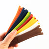 A hand holds a fan of colorful silicone watch bands, including orange, blue, green, and yellow.