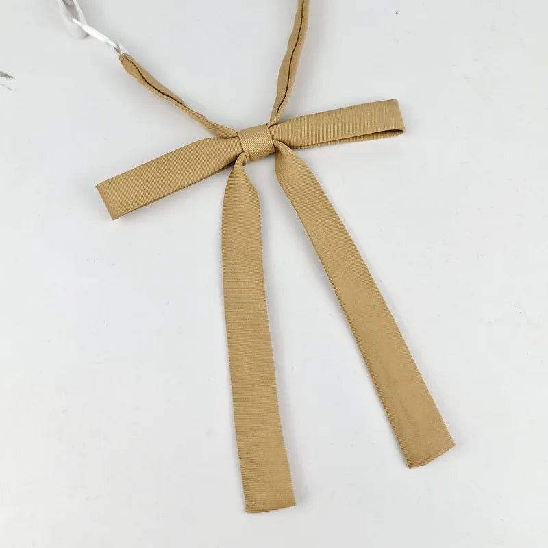 A beige fabric ribbon tied in a butterfly shape, used as a tie set for students.
