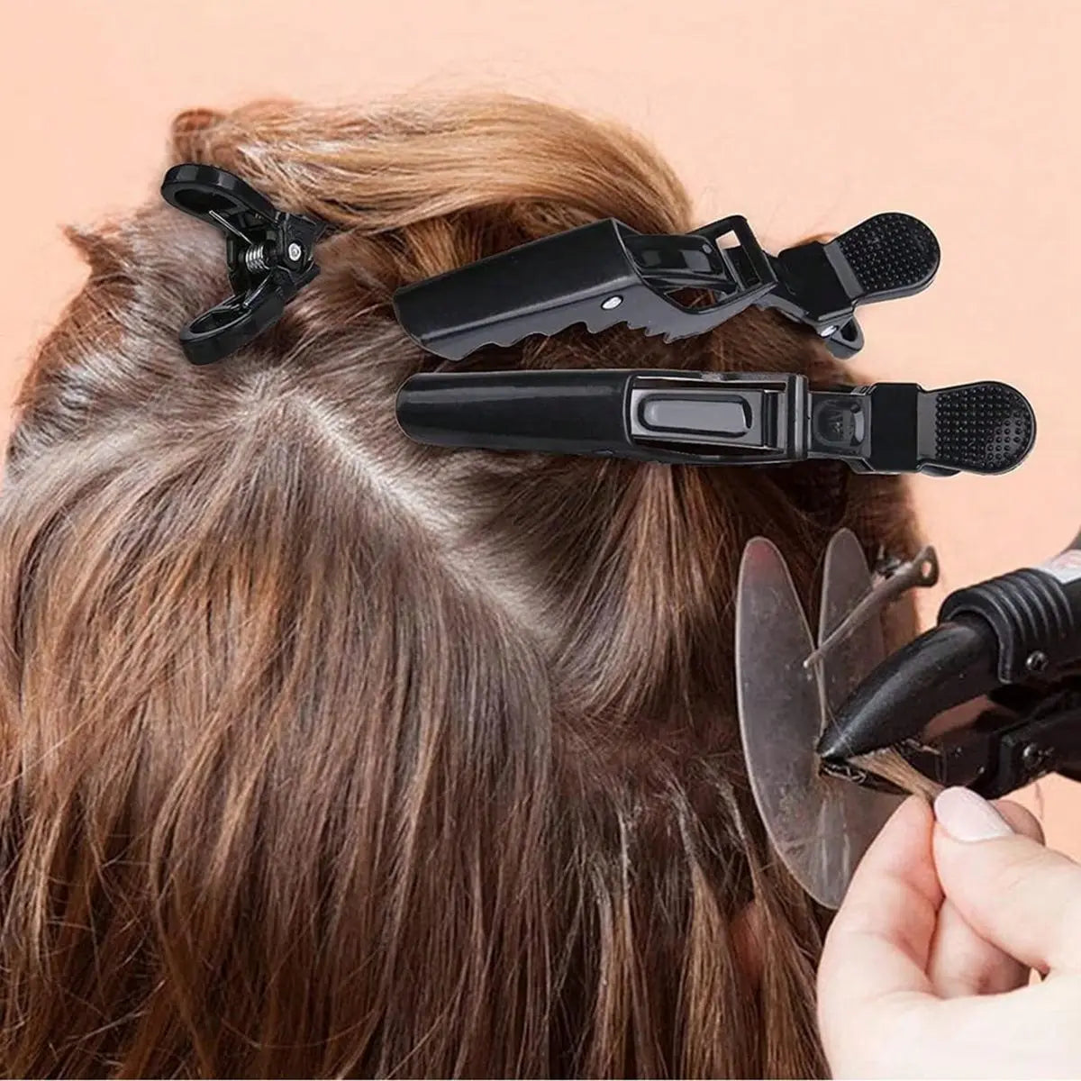A set of black professional multifunctional hair sectioning clips being used to style brown hair.