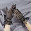 Pair of sheer lace fishnet evening gloves worn by a person against a gray fabric background.