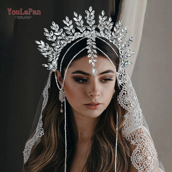 A woman wearing a sparkling rhinestone bridal crown headband and lace veil.