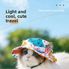 Un chat blanc et gris duveteux portant un chapeau de plage coloré à motifs.