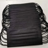 A stack of black 3-layer disposable face masks for adult protection