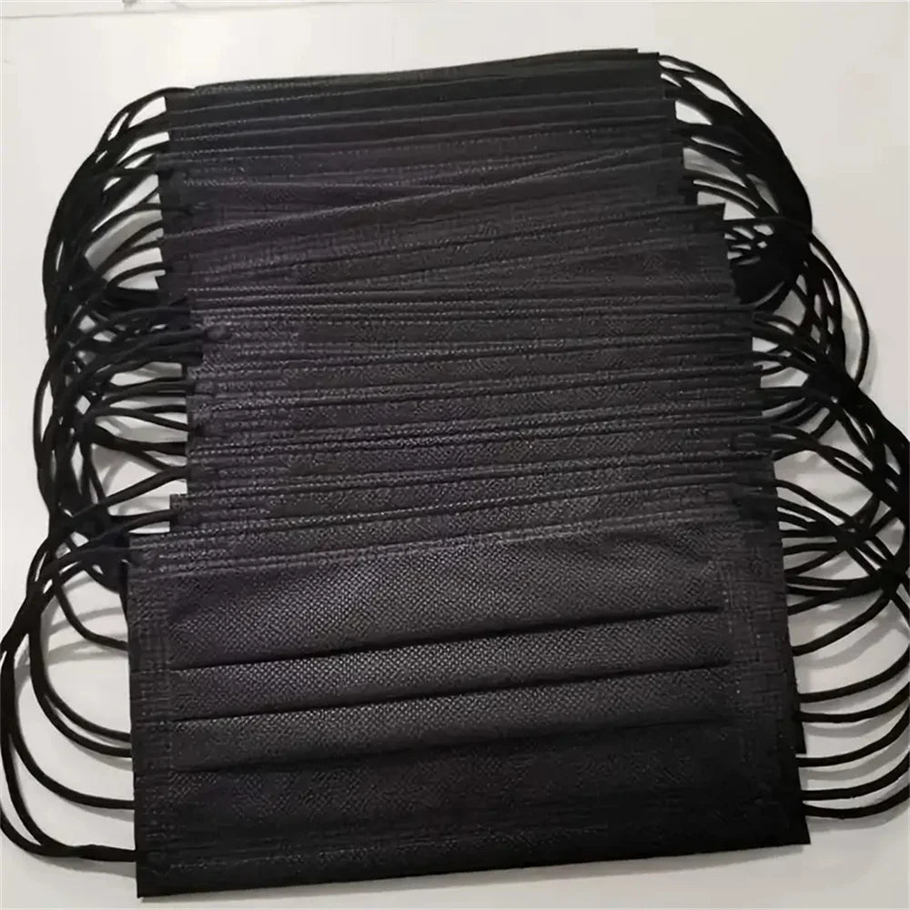 A stack of black 3-layer disposable face masks for adult protection
