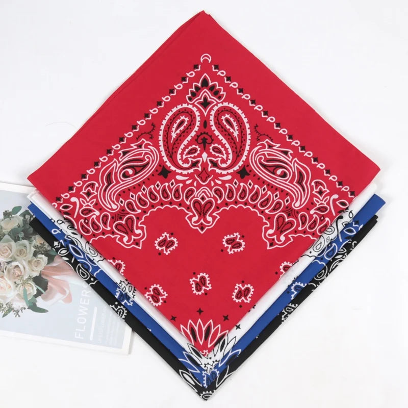 A red paisley bandana scarf with white embroidery is folded and displayed on a white background.