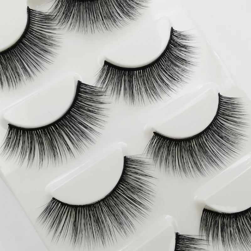 A set of handmade mink strip eyelashes displayed on a white plastic tray.