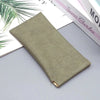 A rectangular olive green PU leather storage bag lying on a light gray surface next to a book.