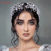A close-up of a woman wearing a silver crystal bridal headband with delicate floral accents.