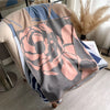 A beige and gray scarf or shawl wrap featuring a large pink rose floral pattern on a light blue background.