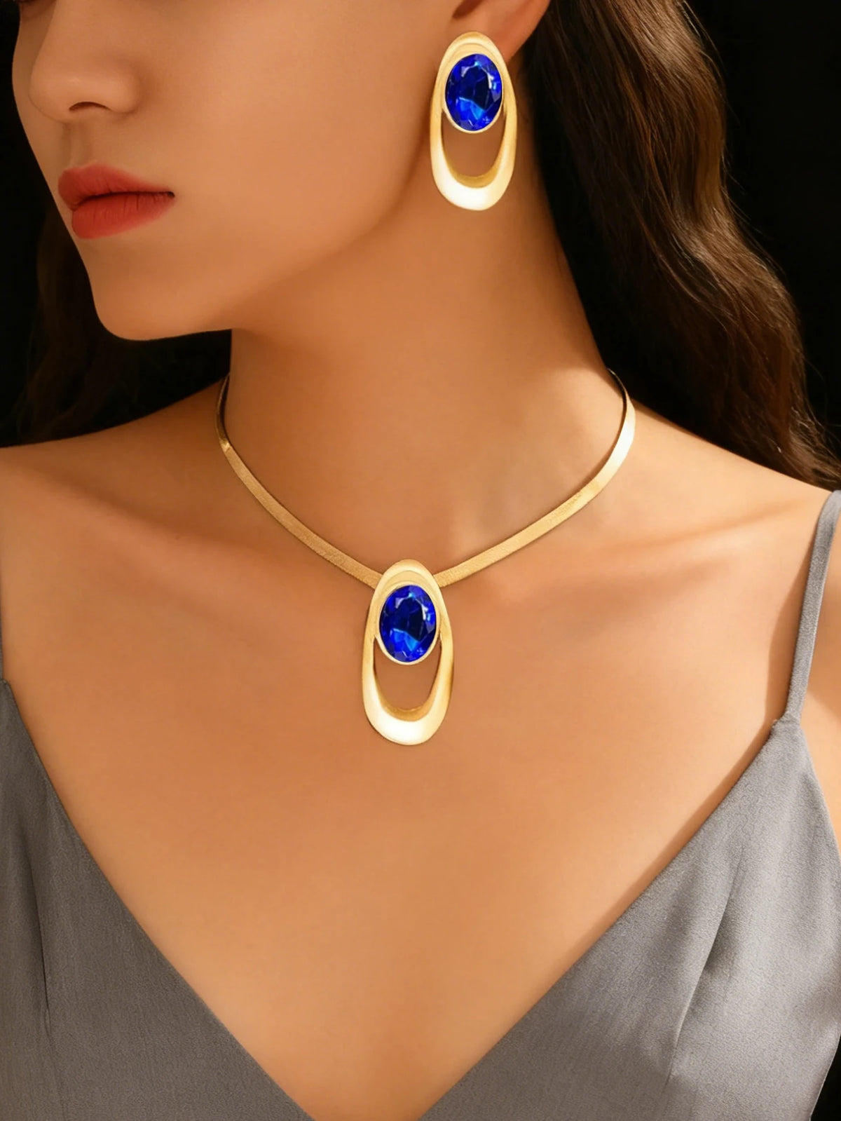 Gold and blue gemstone necklace set featuring a pendant and matching hoop earrings