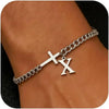 A close-up of a personalized stainless steel cross Cuban chain bracelet worn on a wrist.