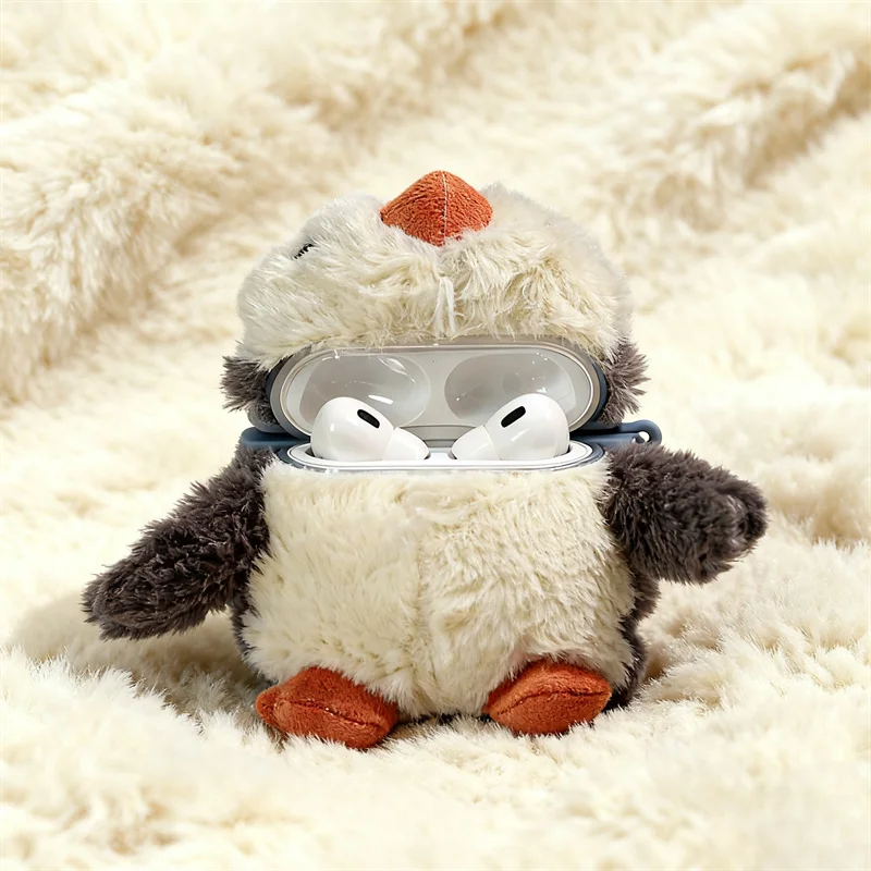 Un juguete de pingüino de peluche esponjoso con detalles naranjas, descansando sobre una superficie blanca texturizada, con s