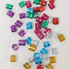 A collection of colorful metal hair rings and clips in various shades including pink, purple, green, and gold.