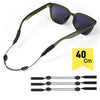 A pair of olive green sunglasses with an adjustable strap and multiple retainer cords shown next to a measurement scale.