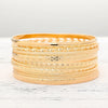 A stack of elegant gold hexagon star twist bangles displayed on a white surface.