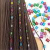 Close-up of dark brown hair with multicolor dreadlock rings and braids, featuring various colored plastic beads.