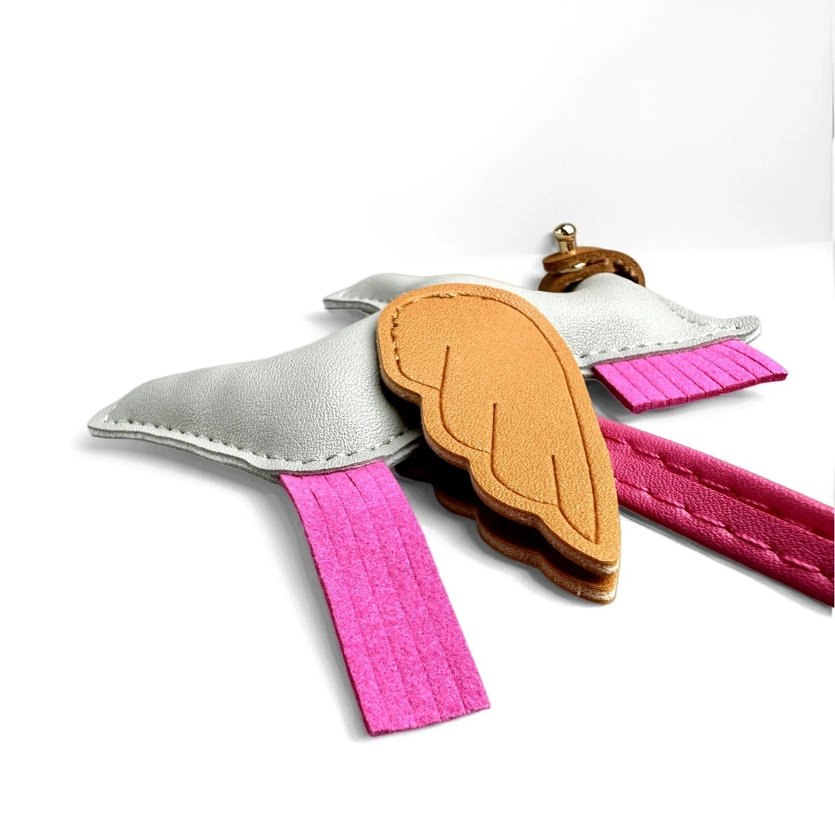 A keychain featuring a silver wing design with an orange feather and a pink strap.