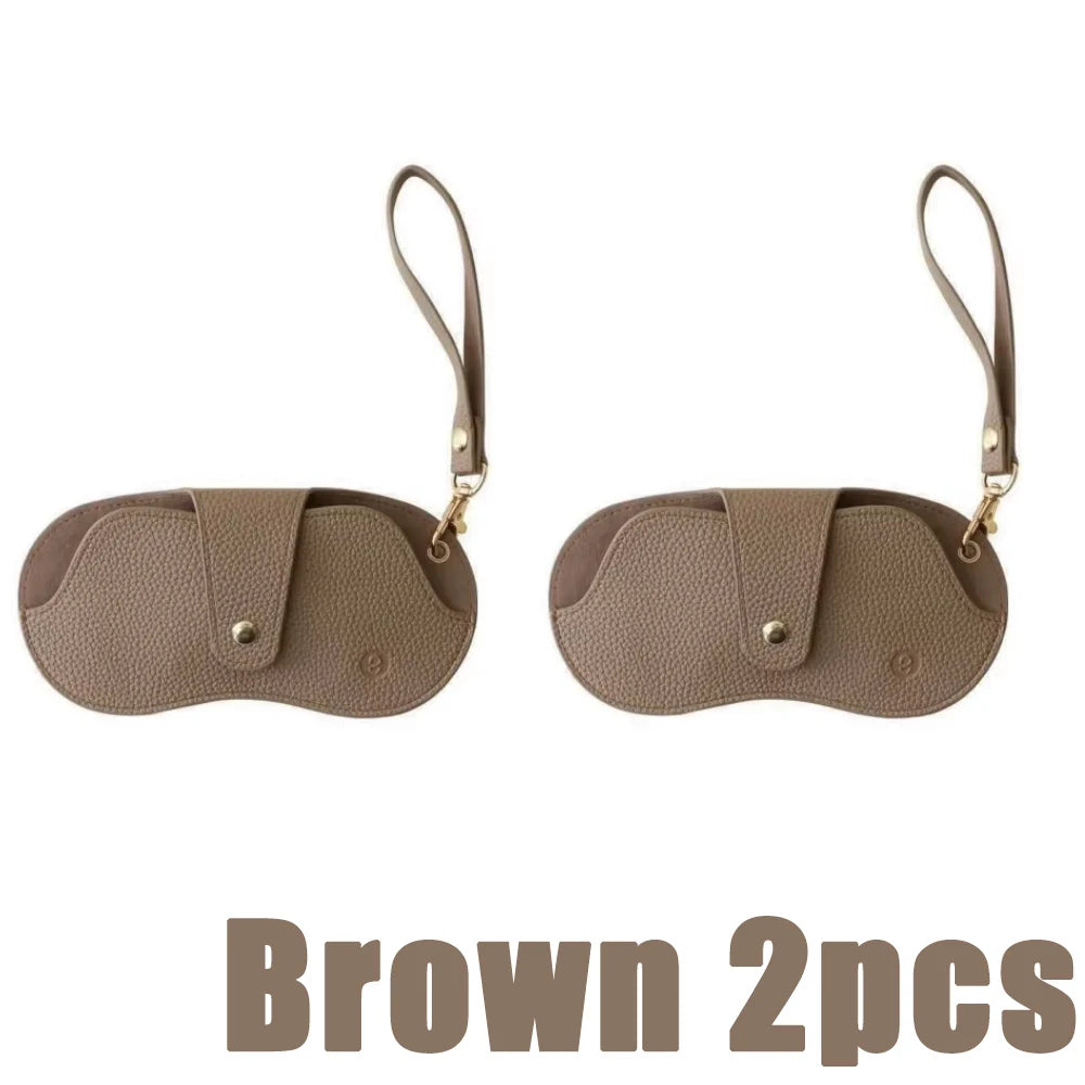 Brown PU leather eyewear storage case with adjustable strap, shown in two pieces.