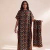 A woman models an elegant long silk blend cover-up robe dress featuring a dark brown and orange patterned fabric.