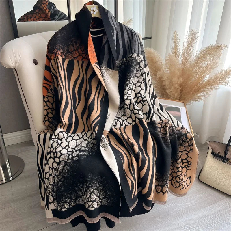 A black and beige patterned luxury plaid cashmere feel scarf and shawl wrap displayed on a white chair.